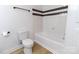 White bathroom features a tiled bathtub with a shower and toilet at 940 N New Hope Rd, Gastonia, NC 28054