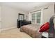 Comfortable bedroom with a full-size bed, dresser, and window with natural light, perfect for relaxation at 9814 Tompkins Ln, Waxhaw, NC 28173