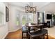 Cozy dining area adjacent to the living room with views to the backyard, stylish light fixture, and modern furniture at 9814 Tompkins Ln, Waxhaw, NC 28173