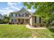 Charming two-story home with a stone and siding exterior, black shutters, and a well-manicured lawn at 9814 Tompkins Ln, Waxhaw, NC 28173
