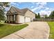 View of the home's exterior showing the driveway, three-car garage, and landscaping at 9814 Tompkins Ln, Waxhaw, NC 28173