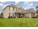 Charming two-story home with a well-maintained lawn, stone accents, and black shutters under a bright sky at 9814 Tompkins Ln, Waxhaw, NC 28173