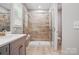 Bathroom featuring tiled shower with a glass enclosure and a built-in bench at 9842 Quercus Ln, Huntersville, NC 28078