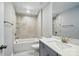 Modern bathroom featuring a shower-over-tub with elegant marble-style tile surround and a vanity with quartz countertops at 9842 Quercus Ln, Huntersville, NC 28078