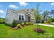 Well-manicured front yard with a stone entryway, shrubbery, and newly planted tree at 9842 Quercus Ln, Huntersville, NC 28078