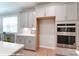 A kitchen features stainless steel double ovens, ample cabinetry, and white countertops, combining functionality with modern design elements at 9842 Quercus Ln, Huntersville, NC 28078