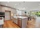 Open kitchen featuring stainless appliances, an island with a farmhouse sink, and quartz countertops at 9842 Quercus Ln, Huntersville, NC 28078