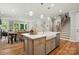 Spacious kitchen island featuring a sink, quartz countertops, stainless appliances, and hardwood floors at 9842 Quercus Ln, Huntersville, NC 28078