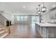 Open-concept living room featuring hardwood floors, a fireplace, natural light and an island with sink at 9934 Cask Way, Huntersville, NC 28078