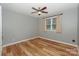 A cozy bedroom with hardwood floors, a ceiling fan, and a large window for natural light at 10304 Squires Way # 18, Cornelius, NC 28031