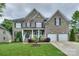 Beautiful two-story brick home with a well-manicured lawn, front porch, attached two-car garage, and decorative fountain at 10304 Squires Way # 18, Cornelius, NC 28031