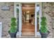 Inviting entrance with brick detailing, potted plants, and bright, open foyer at 10304 Squires Way # 18, Cornelius, NC 28031