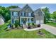 Beautiful brick home with manicured lawn, mature landscaping, and attached two-car garage at 10304 Squires Way # 18, Cornelius, NC 28031
