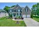 Elegant brick home with well-manicured lawn, lush landscaping, and two-car garage at 10304 Squires Way # 18, Cornelius, NC 28031