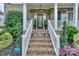Inviting front porch with brick steps, white railings, potted plants, and a decorative wreath on the front door at 10304 Squires Way # 18, Cornelius, NC 28031