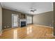 Open living room with a fireplace, a ceiling fan, hardwood floors, and natural light at 10455 Alexander Martin Ave, Charlotte, NC 28277