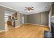 An open-concept living room flows into the kitchen with hardwood floors and a decorative fireplace at 10455 Alexander Martin Ave, Charlotte, NC 28277