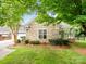 Charming exterior view of a stone-faced home with manicured landscaping and mature trees at 10875 Casetta Dr, Matthews, NC 28105