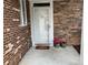 Inviting front entrance with a decorative door, brick and stone accents, and potted flowers at 10875 Casetta Dr, Matthews, NC 28105