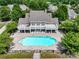 Aerial view of a community pool with lounge chairs and a clubhouse, surrounded by trees at 10875 Casetta Dr, Matthews, NC 28105