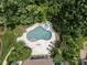 Aerial view of backyard featuring a pool, outdoor furniture, and lush greenery with shade trees at 1103 Mapesbury Ln, Waxhaw, NC 28173