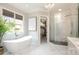 Bright bathroom with a modern free-standing tub, marble floors, and chandelier at 1103 Mapesbury Ln, Waxhaw, NC 28173