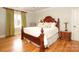 Comfortable bedroom featuring hardwood floors, large bed with decorative pillows and chandelier at 1103 Mapesbury Ln, Waxhaw, NC 28173