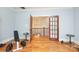 Home gym with hardwood floors, weights, exercise equipment and glass panel doors to the hallway at 1103 Mapesbury Ln, Waxhaw, NC 28173