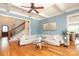 Open living room with hardwood floors, blue accent wall, and ample seating at 1103 Mapesbury Ln, Waxhaw, NC 28173