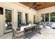 Covered patio with an outdoor dining table and comfortable seating area overlooking the backyard at 1103 Mapesbury Ln, Waxhaw, NC 28173