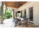Covered patio with stained wood ceiling, ceiling fan, exterior seating, dining table and access to the backyard at 1103 Mapesbury Ln, Waxhaw, NC 28173