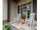 Cozy front porch featuring two rocking chairs and stone flooring, perfect for enjoying the outdoors at 1103 Mapesbury Ln, Waxhaw, NC 28173