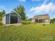 Grassy backyard features detached garage with modern home, framed by mature trees at 11225 Island View Ln, Lancaster, SC 29720