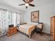 Neutral bedroom showcasing a ceiling fan, artwork, and a comfortable bed with wooden furniture at 11225 Island View Ln, Lancaster, SC 29720