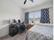 Bedroom featuring a desk, a black computer chair, blue patterned curtains, and a bed with gray and white patterned comforter at 11225 Island View Ln, Lancaster, SC 29720