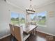 Bright dining room with a rustic wood table, stylish chandelier, and large windows overlooking the backyard at 11225 Island View Ln, Lancaster, SC 29720