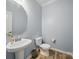 Half bath features pedestal sink, wood look flooring, and a standard toilet at 11225 Island View Ln, Lancaster, SC 29720