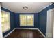 Bedroom with blue walls and wood floors and natural light streaming in from windows at 1216 Mountain Ave, Gastonia, NC 28052