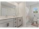 Bathroom with double sink vanity, white cabinets, and tiled shower/tub at 12536 Stoneybrook Pkwy, Huntersville, NC 28078
