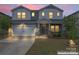 Charming two-story home with a two-car garage and stone veneer accents at dusk at 12536 Stoneybrook Pkwy, Huntersville, NC 28078