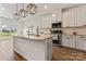 Bright kitchen features an island with a breakfast bar, stainless appliances, and modern pendant lighting at 12536 Stoneybrook Pkwy, Huntersville, NC 28078