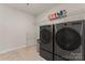 Well-lit laundry room with front-load washer and dryer at 12536 Stoneybrook Pkwy, Huntersville, NC 28078