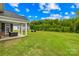 Picturesque backyard with a lush green lawn, mature trees, and a covered patio at 126 Still Creek Dr, Mooresville, NC 28115