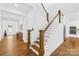 Elegant staircase with hardwood steps, white railings, and views of the bright interior at 126 Still Creek Dr, Mooresville, NC 28115