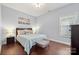 Cozy bedroom featuring wood floors, a large window with blinds, and a bed with decorative pillows at 12663 Windyedge Rd, Huntersville, NC 28078