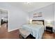 Bedroom with wood floors, neutral paint, and a bed with decorative pillows underneath a modern light fixture at 12663 Windyedge Rd, Huntersville, NC 28078