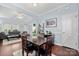 Elegant dining area with hardwood floors, a wooden table, and seamless flow to the living room at 12663 Windyedge Rd, Huntersville, NC 28078