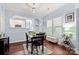 Open dining room with light blue walls features dark wood table with seating for four and light fixture at 12663 Windyedge Rd, Huntersville, NC 28078