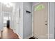 Light filled entryway features wood laminate flooring, coat hooks, and white painted front door with half circle window at 12663 Windyedge Rd, Huntersville, NC 28078