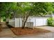 View of the home's exterior featuring a white fence, a neatly mulched garden, and a well-maintained landscape at 12663 Windyedge Rd, Huntersville, NC 28078